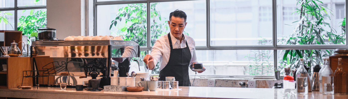 Barista holding coffee cup at counter