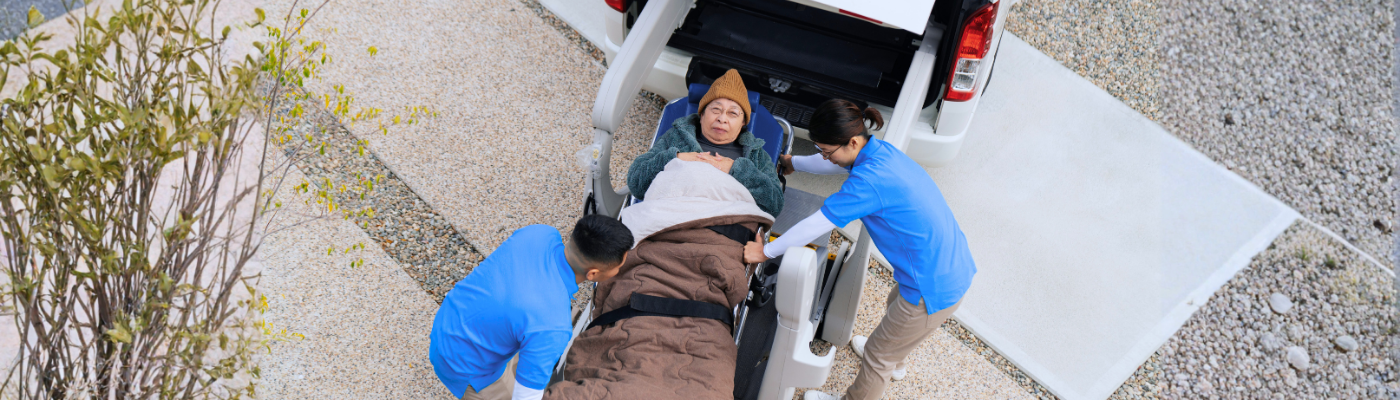 Aerial view of carers loading a patient into a van
