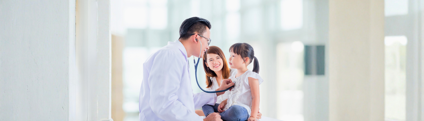 Asian doctor examining a girl by stethoscope