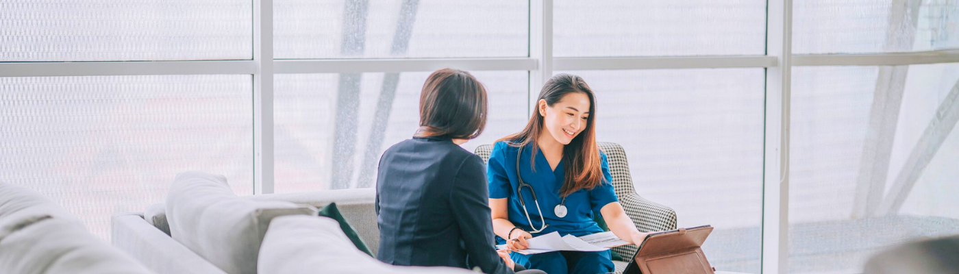 Asian female doctor seated with patient