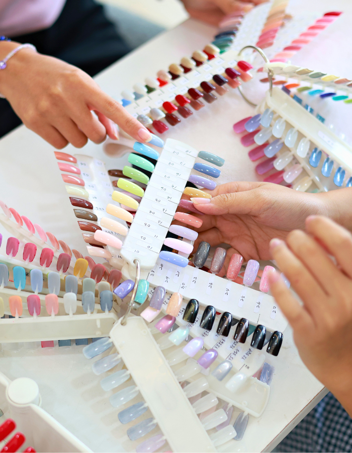 Young female business owner assisting customer in nail salon