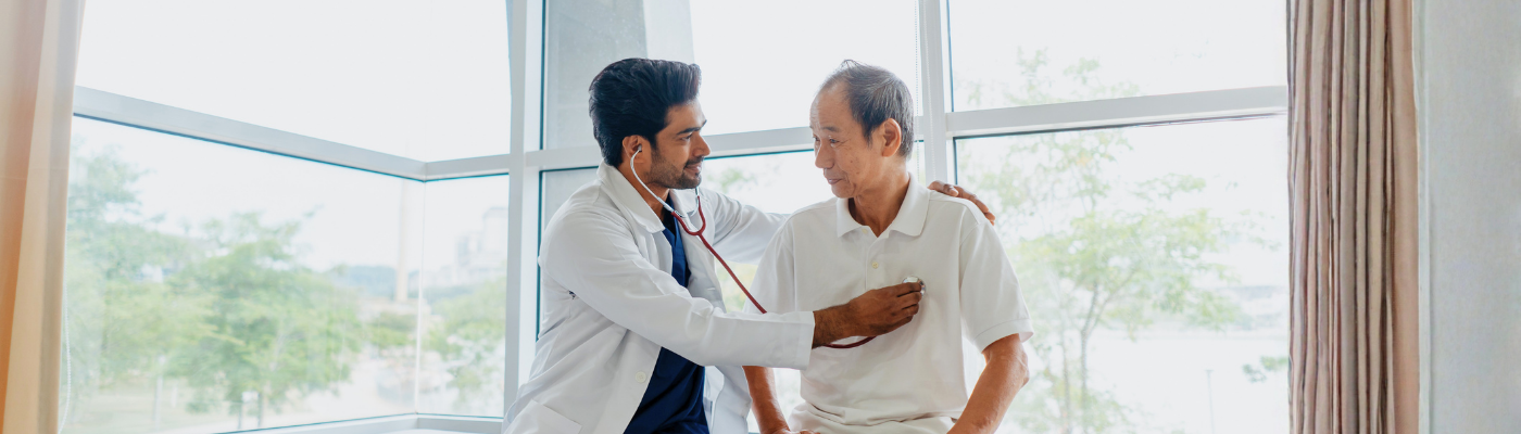 Doctor examining senior man patient with a stethoscope in clinic