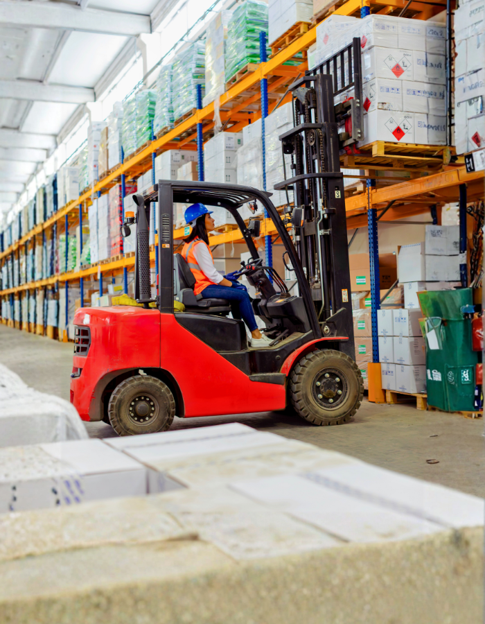 Female warehouse worker operating forklift