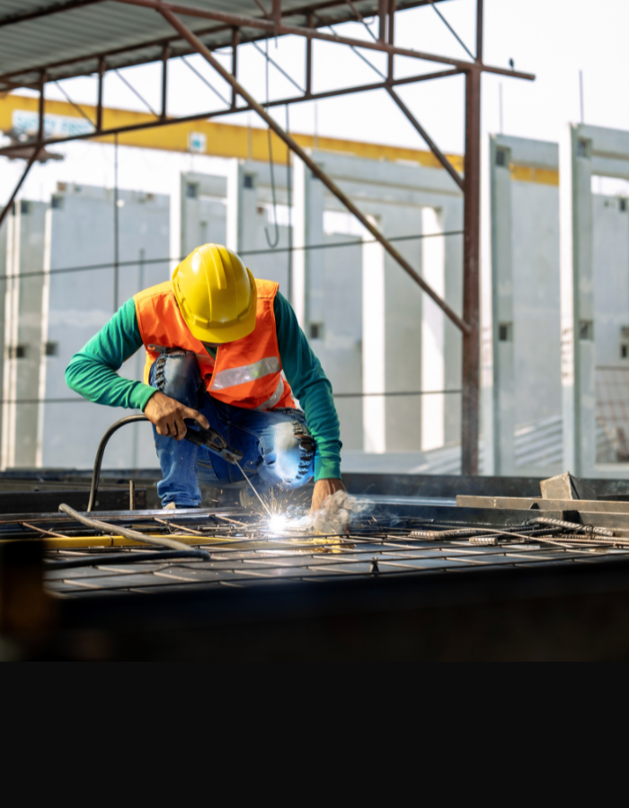 Worker at a construction site welds metal structures
