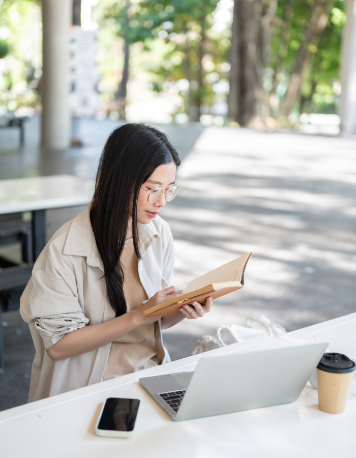 Glass Asian female student sitting reading book