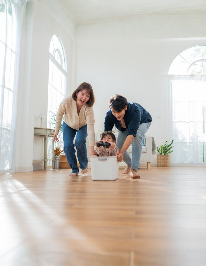 Asian parents playing with child in a bright room