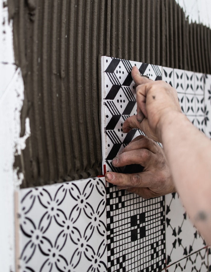 Professional builder applying ceramic tiles on a wall