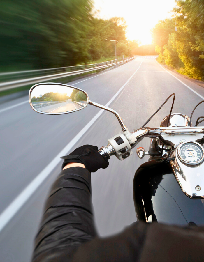 Motorcyclist riding through the empty asphalt road 