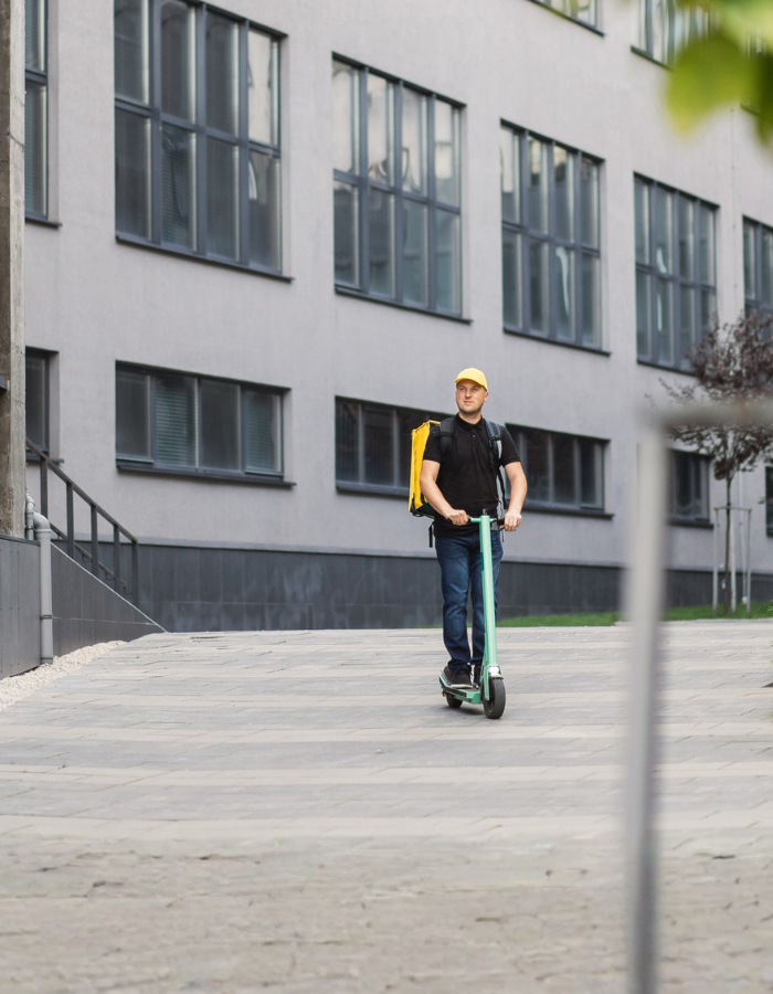 Man courier on scooter in town streets