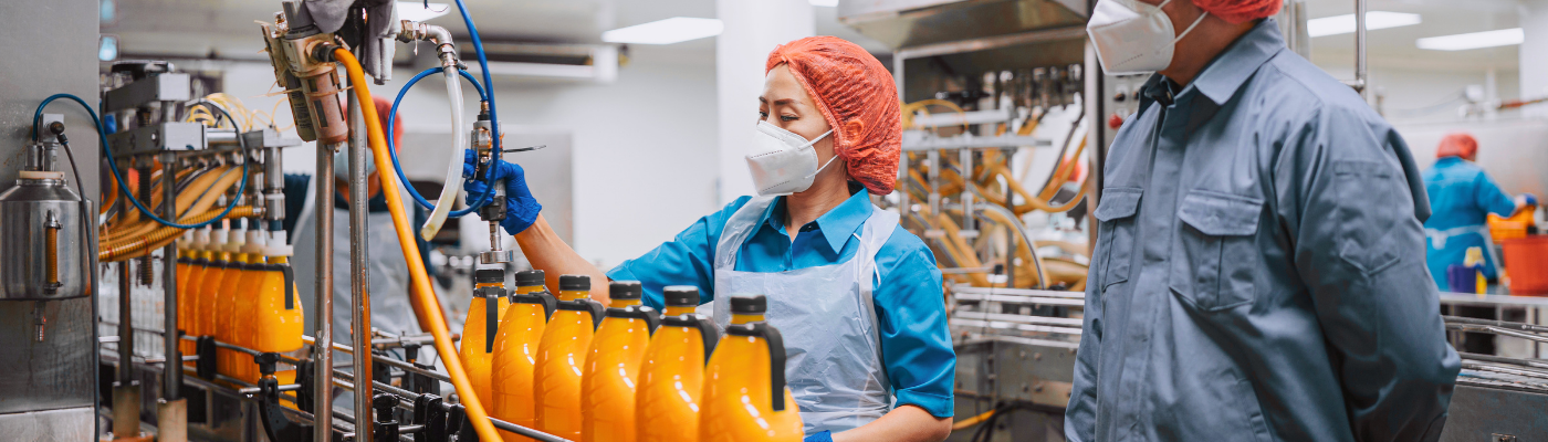 Factory worker at the fruit juice production line