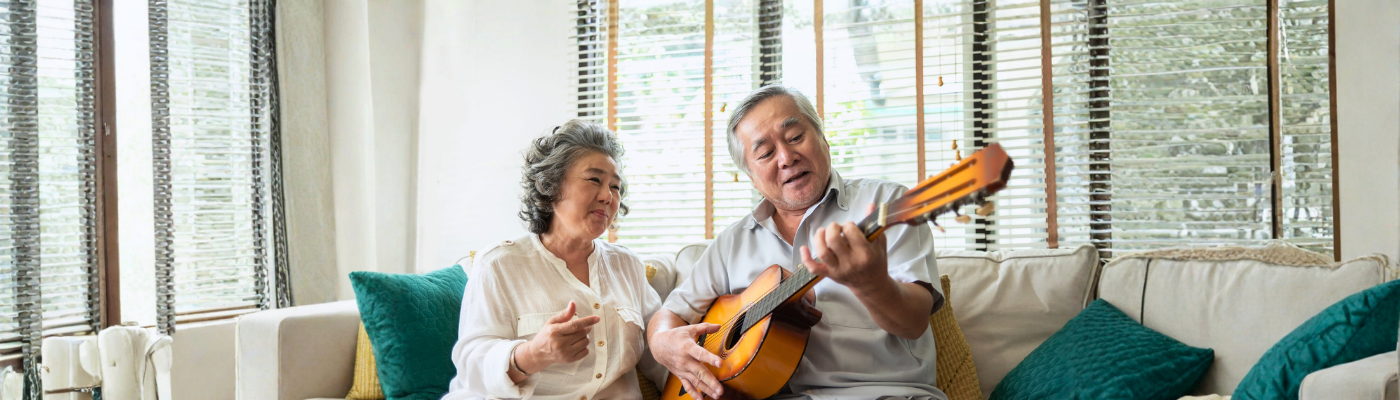 Older couple enjoying with singing and guitar together