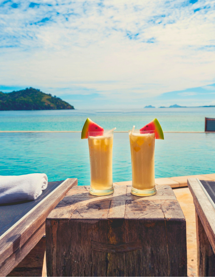 Cocktails by the pool with beach in the background
