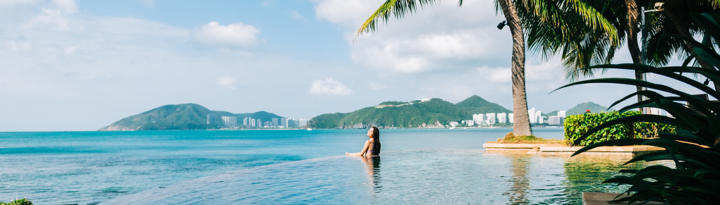 Woman in swimming pool on beautiful tropical bay
