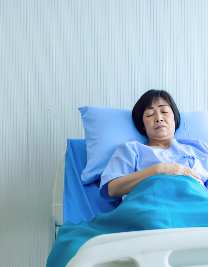 Older sick woman patient lay on bed in hospital