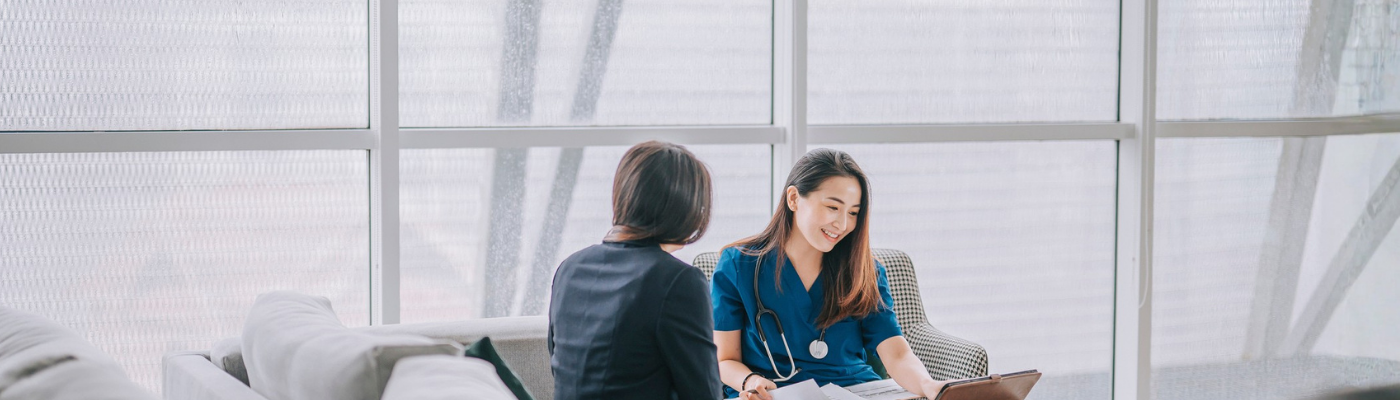 Asian female doctor explaining medical report to a female patient